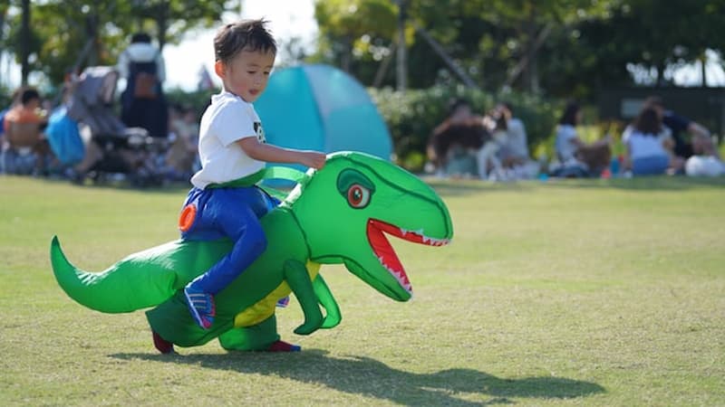恐竜に乗る子ども